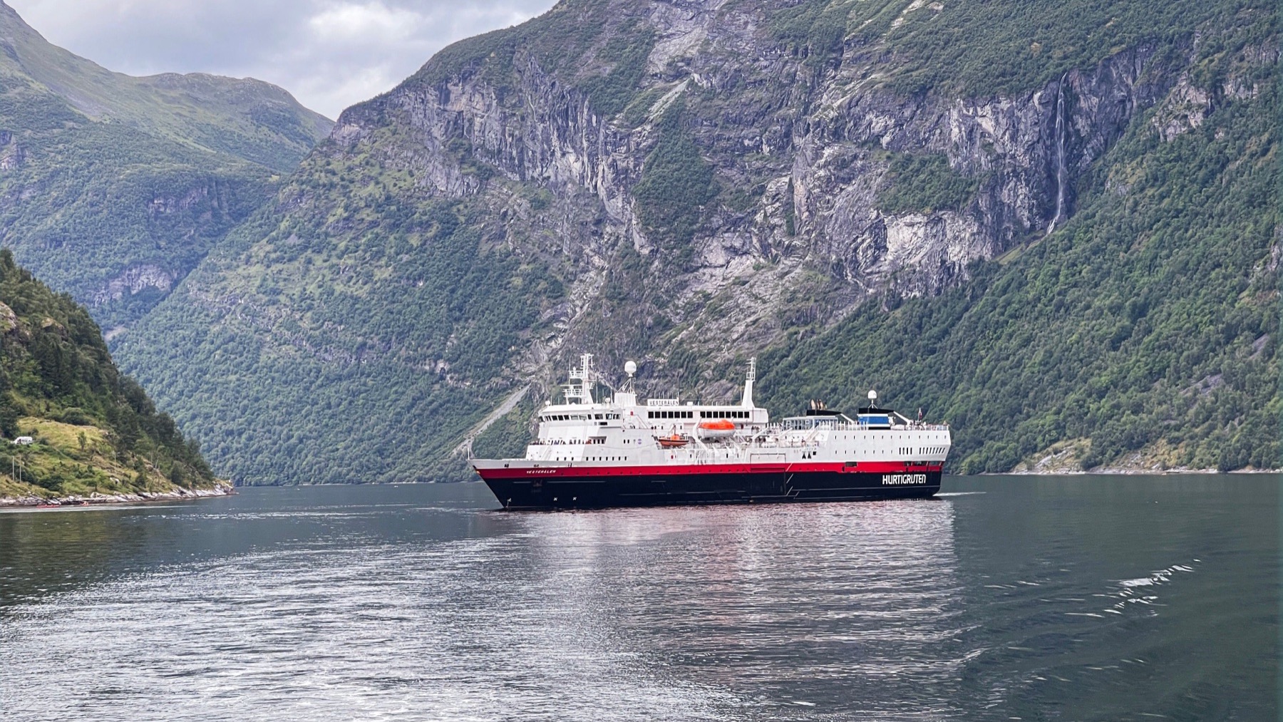 Cruise ship sailing through a scenic Norwegian fjord