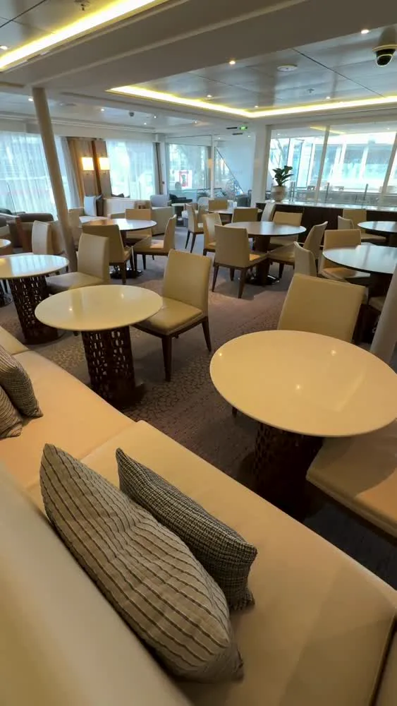 Window-side seating and tables in Viking Rinda's lounge, from LVC ship-tour footage